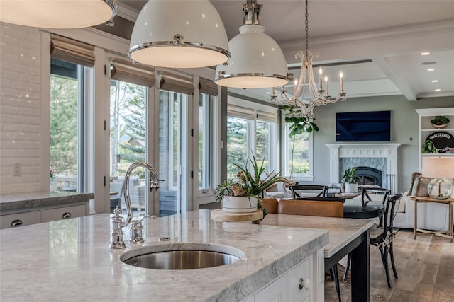 3070 River Lakes Dr, Whitefish, MT 59937 - kitchen with a sink, open floor plan, white cabinets, ornamental molding, and a fireplace