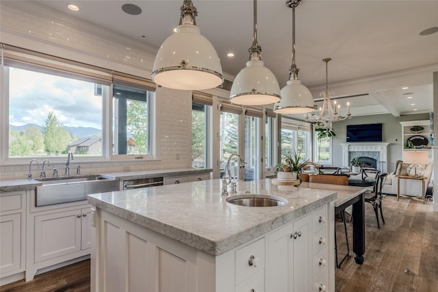 3070 River Lakes Dr, Whitefish, MT 59937 - kitchen featuring a sink, open floor plan, a premium fireplace, white cabinetry, and ornamental molding