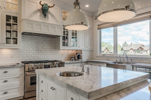 3070 River Lakes Dr, Whitefish, MT 59937 - kitchen featuring stainless steel stove, a sink, white cabinetry, backsplash, and recessed lighting