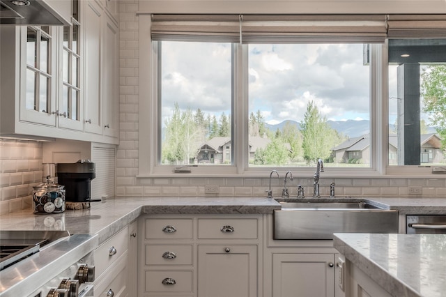 3070 River Lakes Dr, Whitefish, MT 59937 - kitchen with a sink, white cabinets, decorative backsplash, glass insert cabinets, and light stone counters