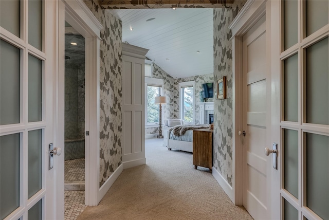 3070 River Lakes Dr, Whitefish, MT 59937 - hallway with wallpapered walls, lofted ceiling, baseboards, light carpet, and french doors