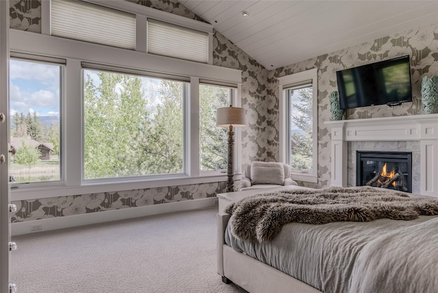 3070 River Lakes Dr, Whitefish, MT 59937 - bedroom with wallpapered walls, carpet floors, lofted ceiling, and a glass covered fireplace