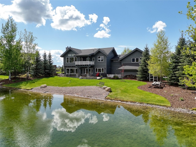 3070 River Lakes Dr, Whitefish, MT 59937 - back of property featuring a balcony, a lawn, a water view, and a chimney