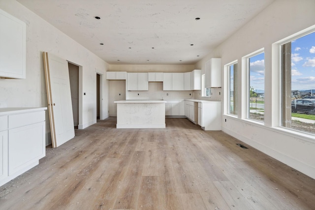 623 Holstein Way, Kalispell, MT 59901 - kitchen with light wood-type flooring, a center island, white cabinets, and baseboards