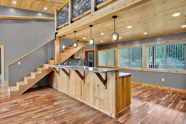 26 Two Rivers Rd, Saint Regis, MT 59866 - kitchen featuring wooden ceiling, light wood-style flooring, a peninsula, baseboards, and light stone counters