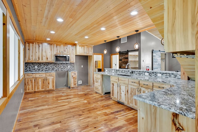 26 Two Rivers Rd, Saint Regis, MT 59866 - kitchen with stainless steel microwave, a barn door, light brown cabinetry, wooden ceiling, and a peninsula