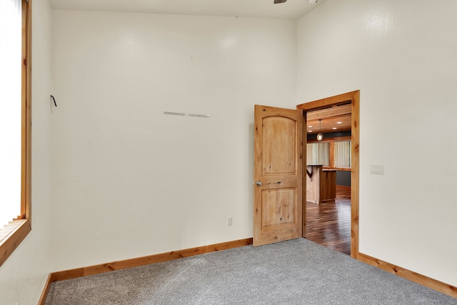 26 Two Rivers Rd, Saint Regis, MT 59866 - empty room with baseboards, carpet floors, ceiling fan, and a high ceiling