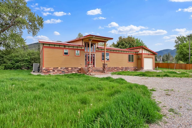 26 Two Rivers Rd, Saint Regis, MT 59866 - view of front of house featuring a garage, a mountain view, driveway, and central AC unit