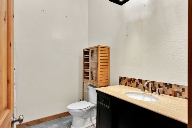 26 Two Rivers Rd, Saint Regis, MT 59866 - bathroom featuring toilet, decorative backsplash, vanity, and baseboards