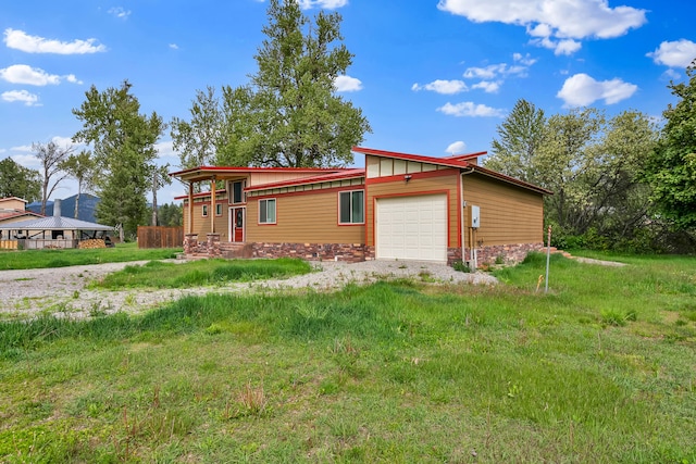 26 Two Rivers Rd, Saint Regis, MT 59866 - view of front facade featuring a garage and stone siding