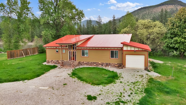 26 Two Rivers Rd, Saint Regis, MT 59866 - view of front of property featuring an attached garage, a mountain view, metal roof, driveway, and a wooded view