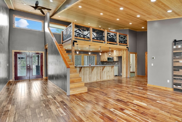 26 Two Rivers Rd, Saint Regis, MT 59866 - unfurnished living room with a high ceiling, wood ceiling, french doors, stairway, and light wood-style flooring