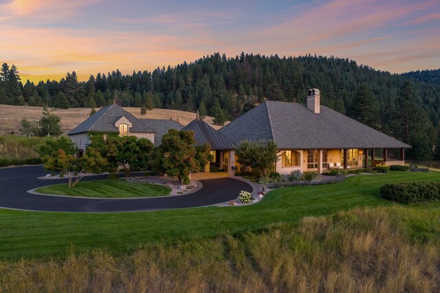 2761 Contour Rd, Missoula, MT 59802 - view of front of house featuring a forest view, a front lawn, a chimney, and curved driveway