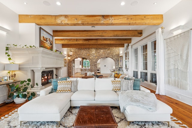 2761 Contour Rd, Missoula, MT 59802 - living room with a lit fireplace, beam ceiling, wood finished floors, recessed lighting, and arched walkways