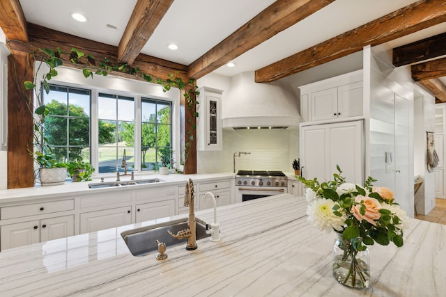 2761 Contour Rd, Missoula, MT 59802 - kitchen with stainless steel stove, decorative backsplash, custom range hood, white cabinetry, and beam ceiling