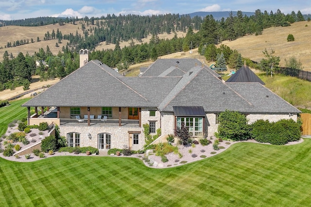 2761 Contour Rd, Missoula, MT 59802 - back of property with a balcony, stone siding, a chimney, and a shingled roof