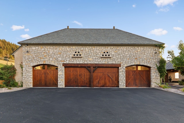 2761 Contour Rd, Missoula, MT 59802 - view of property exterior featuring stone siding, a garage, and driveway