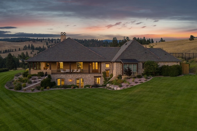 2761 Contour Rd, Missoula, MT 59802 - view of front of home with a chimney, a yard, stone siding, and roof with shingles