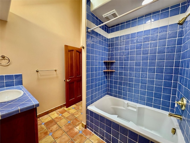 444 Windwalker Trl, Stevensville, MT 59870 - bathroom featuring tiled shower / bath, vanity, tile patterned flooring, and baseboards