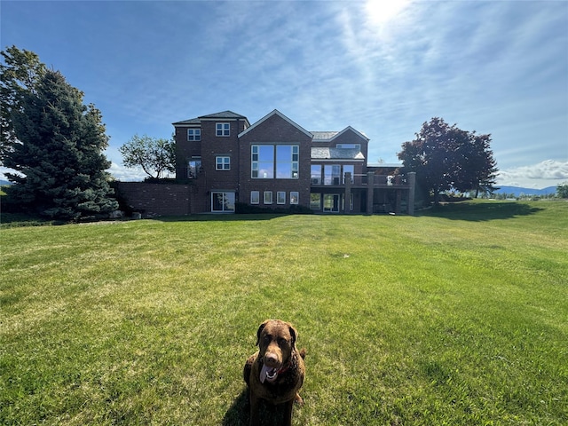 444 Windwalker Trl, Stevensville, MT 59870 - rear view of house with a lawn and brick siding