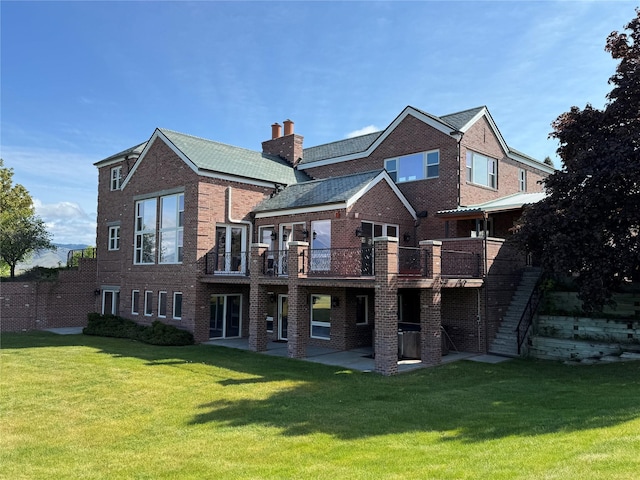 444 Windwalker Trl, Stevensville, MT 59870 - back of house with brick siding, a yard, a patio area, a chimney, and a deck
