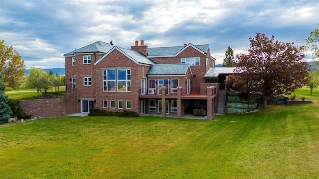 444 Windwalker Trl, Stevensville, MT 59870 - back of house featuring a yard, a patio, a wooden deck, and brick siding