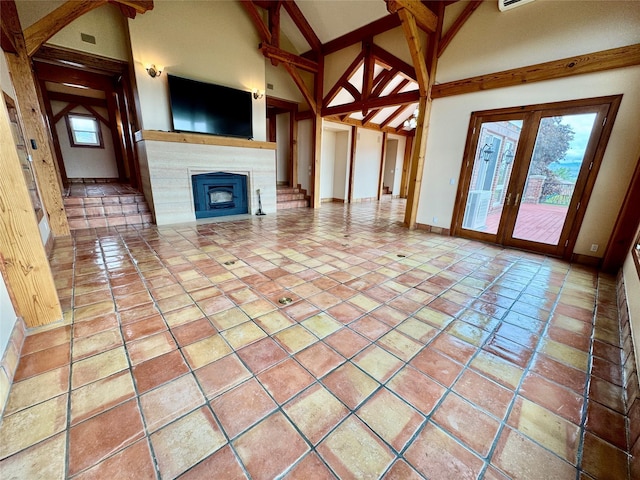 444 Windwalker Trl, Stevensville, MT 59870 - unfurnished living room featuring high vaulted ceiling, baseboards, a fireplace, and beam ceiling