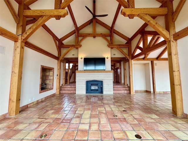 444 Windwalker Trl, Stevensville, MT 59870 - unfurnished living room featuring high vaulted ceiling, a fireplace, baseboards, ceiling fan, and beamed ceiling