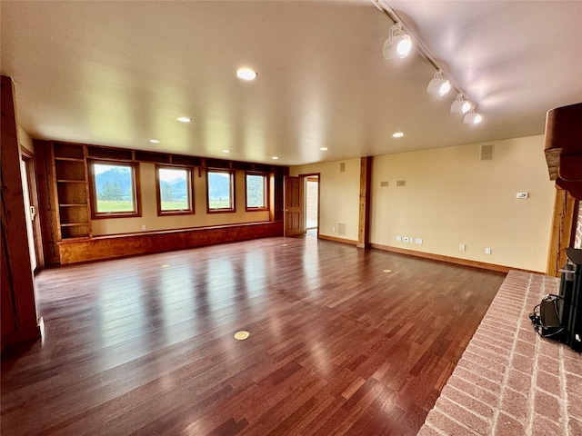 444 Windwalker Trl, Stevensville, MT 59870 - unfurnished living room featuring wood finished floors, rail lighting, a wood stove, and recessed lighting