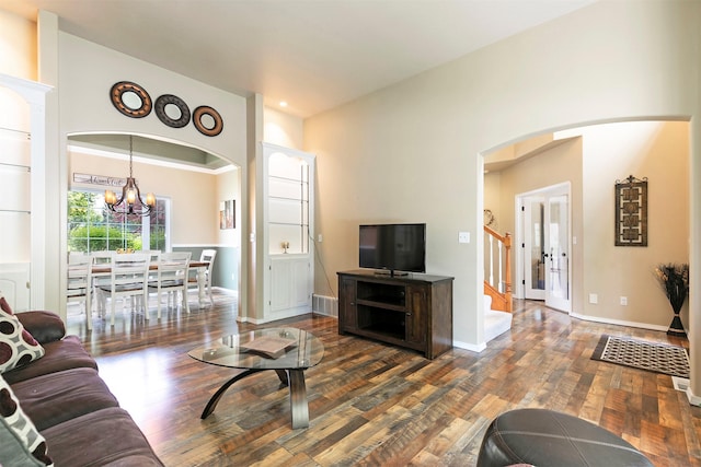 5040 Jordan Ct, Missoula, MT 59803 - living room with dark wood finished floors, a chandelier, stairs, baseboards, and arched walkways