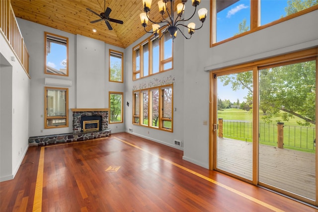 259 Eagle Bend Dr, Bigfork, MT 59911 - unfurnished living room with a towering ceiling, a fireplace, wood finished floors, baseboards, and a chandelier
