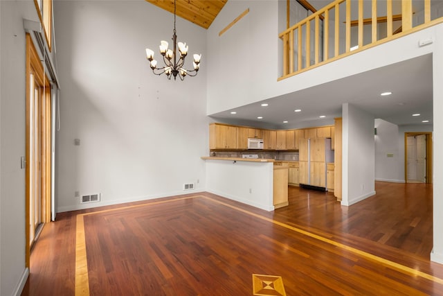 259 Eagle Bend Dr, Bigfork, MT 59911 - unfurnished living room with high vaulted ceiling, a chandelier, dark wood-style flooring, baseboards, and recessed lighting