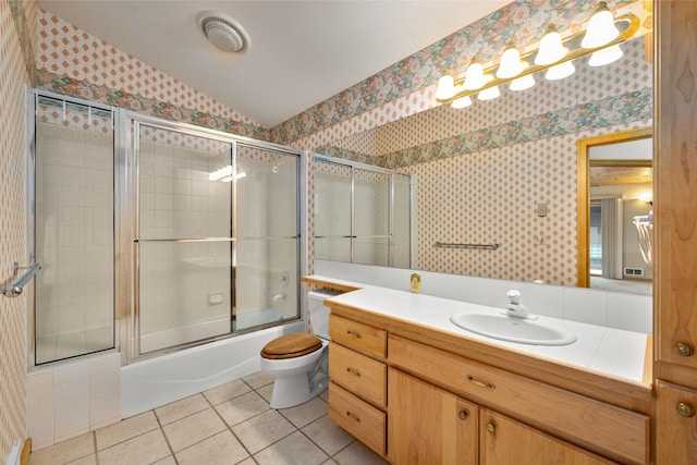 259 Eagle Bend Dr, Bigfork, MT 59911 - full bath featuring wallpapered walls, tile patterned flooring, vanity, enclosed tub / shower combo, and toilet