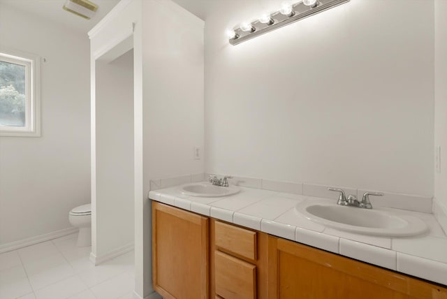 515 W Oregon St, Kalispell, MT 59901 - bathroom featuring toilet, double vanity, tile patterned flooring, and baseboards