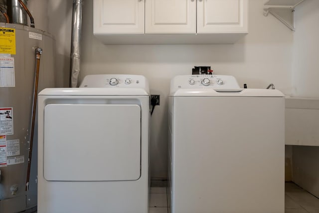 515 W Oregon St, Kalispell, MT 59901 - laundry area featuring washer and dryer, gas water heater, tile patterned floors, and cabinet space