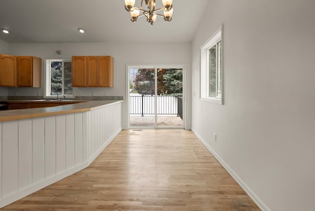 515 W Oregon St, Kalispell, MT 59901 - kitchen with light wood-type flooring, a chandelier, baseboards, recessed lighting, and a sink