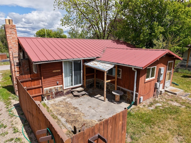 323 B St, Dixon, MT 59831 - back of property featuring a chimney, metal roof, and a patio