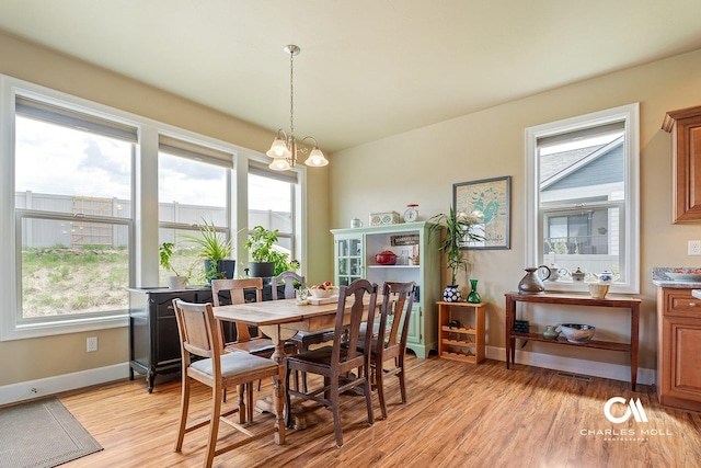 339 Elouise Cobell St, Helena, MT 59601 - dining room with light wood-type flooring, a chandelier, healthy amount of natural light, and baseboards