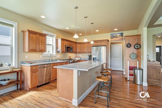 339 Elouise Cobell St, Helena, MT 59601 - kitchen with appliances with stainless steel finishes, light wood-style flooring, a sink, a breakfast bar, and recessed lighting