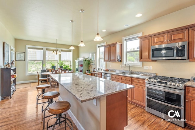 339 Elouise Cobell St, Helena, MT 59601 - kitchen featuring appliances with stainless steel finishes, a sink, a breakfast bar area, light wood-type flooring, and recessed lighting