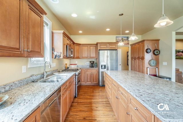 339 Elouise Cobell St, Helena, MT 59601 - kitchen featuring stainless steel appliances, a sink, light wood-style flooring, light stone counters, and hanging light fixtures