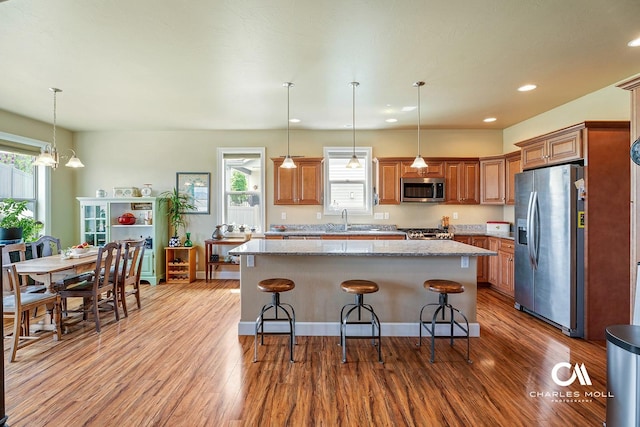 339 Elouise Cobell St, Helena, MT 59601 - kitchen with appliances with stainless steel finishes, a sink, wood finished floors, brown cabinetry, and recessed lighting