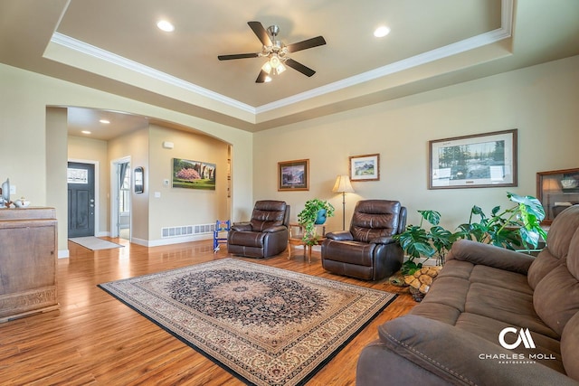 339 Elouise Cobell St, Helena, MT 59601 - living room featuring a tray ceiling, arched walkways, wood finished floors, ornamental molding, and recessed lighting