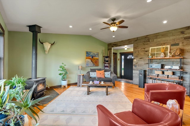 51943 Kuntz Ln, Charlo, MT 59824 - living room featuring a wood stove, lofted ceiling, a ceiling fan, recessed lighting, and wooden walls