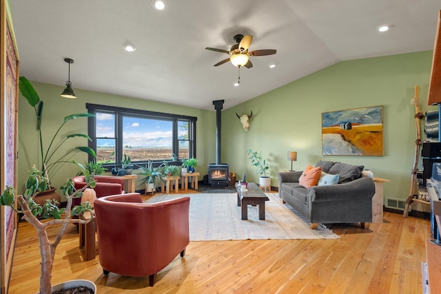 51943 Kuntz Ln, Charlo, MT 59824 - living room with a wood stove, a ceiling fan, light wood-style flooring, vaulted ceiling, and recessed lighting