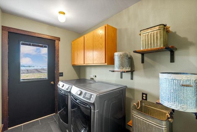 51943 Kuntz Ln, Charlo, MT 59824 - laundry room featuring cabinet space, washing machine and dryer, and dark tile patterned flooring