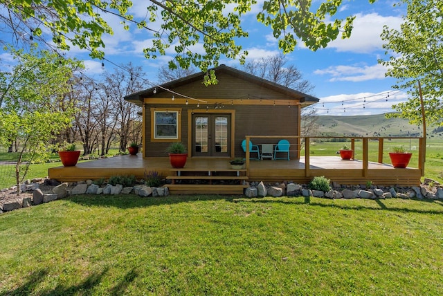 51943 Kuntz Ln, Charlo, MT 59824 - rear view of house with french doors, a deck with mountain view, and a lawn