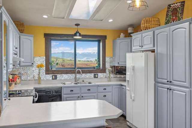 51943 Kuntz Ln, Charlo, MT 59824 - kitchen with white fridge with ice dispenser, a sink, black dishwasher, a peninsula, and light countertops