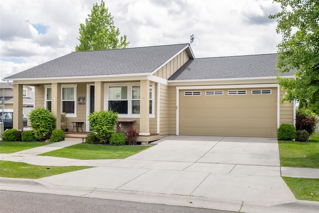 5015 Pius Way, Missoula, MT 59808 - view of front facade featuring a garage, concrete driveway, a front lawn, covered porch, and board and batten siding