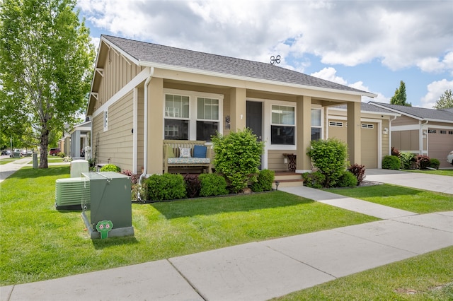 5015 Pius Way, Missoula, MT 59808 - view of front of house featuring board and batten siding, an attached garage, concrete driveway, a porch, and a front yard